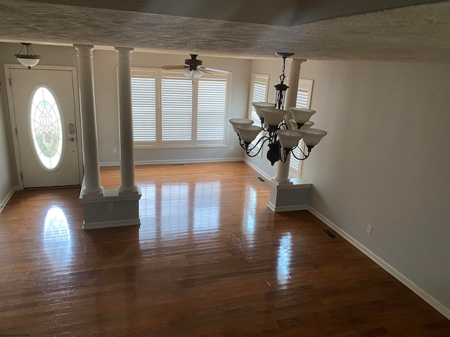 entrance foyer featuring decorative columns, a textured ceiling, and hardwood / wood-style floors