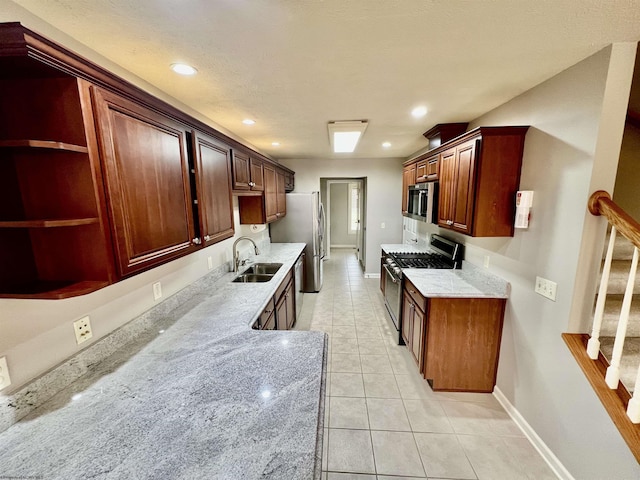kitchen featuring recessed lighting, a sink, stainless steel appliances, light tile patterned floors, and baseboards