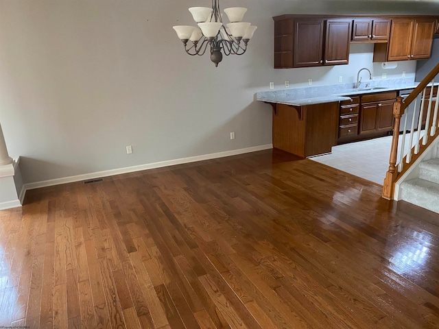 kitchen with a notable chandelier, light hardwood / wood-style floors, hanging light fixtures, and sink