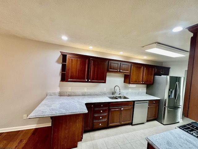 kitchen featuring recessed lighting, stainless steel appliances, open shelves, a sink, and a peninsula