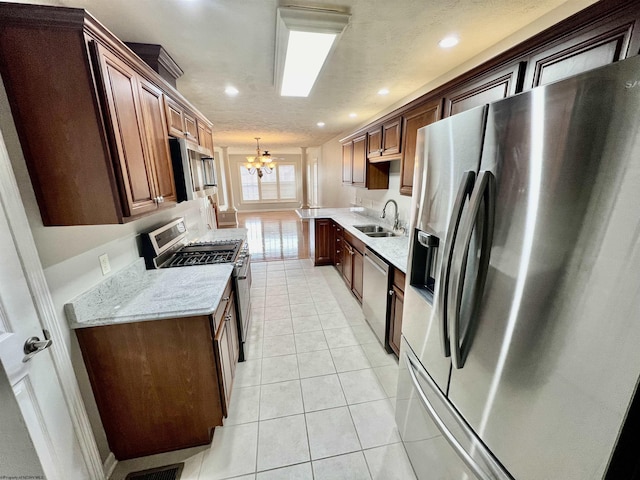 kitchen featuring stainless steel appliances, recessed lighting, a notable chandelier, and a sink