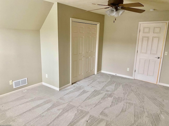 unfurnished bedroom with ceiling fan, a closet, and light carpet