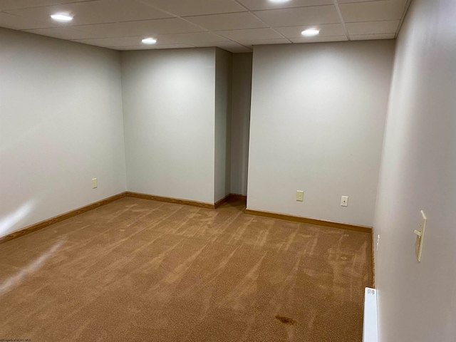 carpeted spare room featuring a baseboard radiator and a paneled ceiling