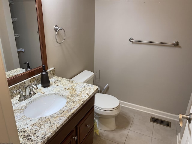 bathroom with visible vents, baseboards, toilet, vanity, and tile patterned flooring