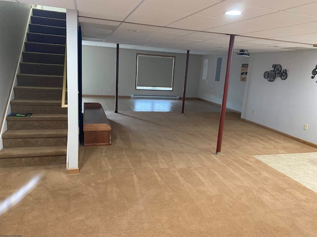 basement with a baseboard heating unit, a drop ceiling, and carpet