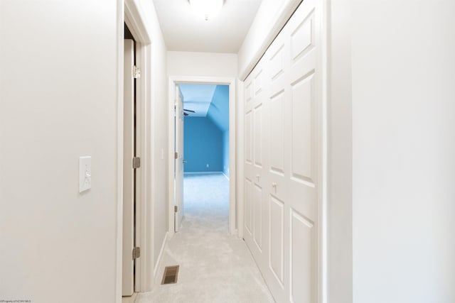 hall featuring visible vents, baseboards, and light carpet