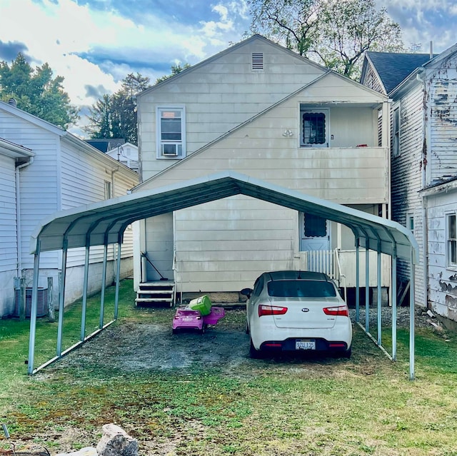 rear view of house featuring central AC, a yard, and a carport