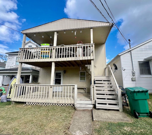 rear view of property featuring a lawn and a deck