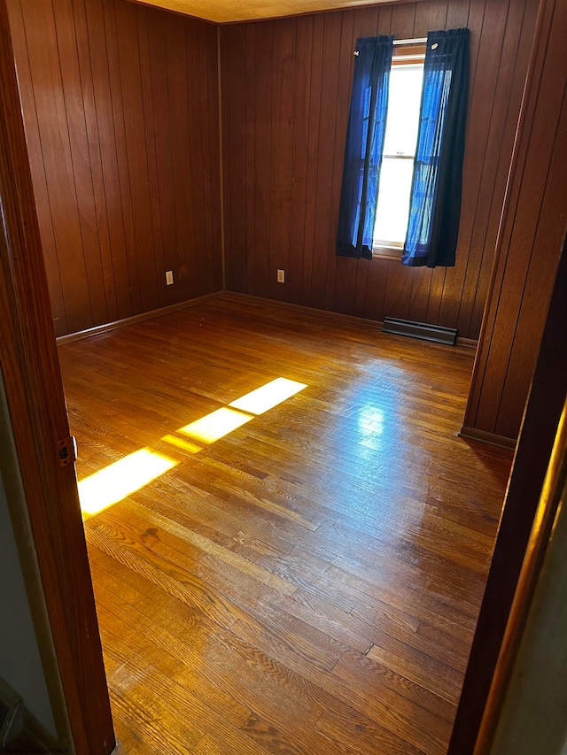 unfurnished room with hardwood / wood-style flooring and wood walls