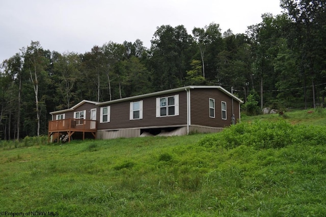 manufactured / mobile home with a front lawn and a wooden deck