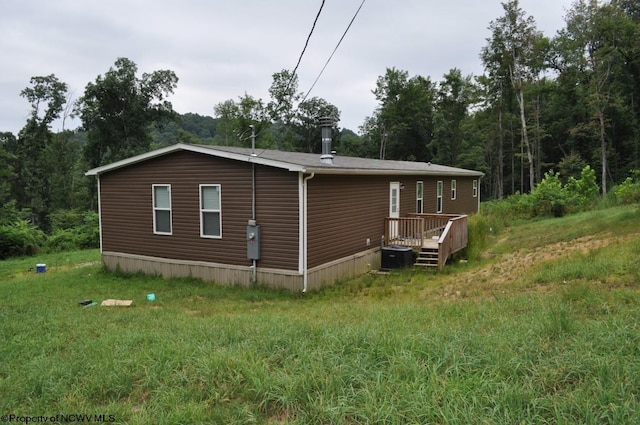 back of house featuring a deck and a lawn