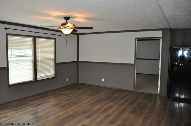 spare room featuring a textured ceiling, lofted ceiling, dark hardwood / wood-style flooring, ornamental molding, and ceiling fan