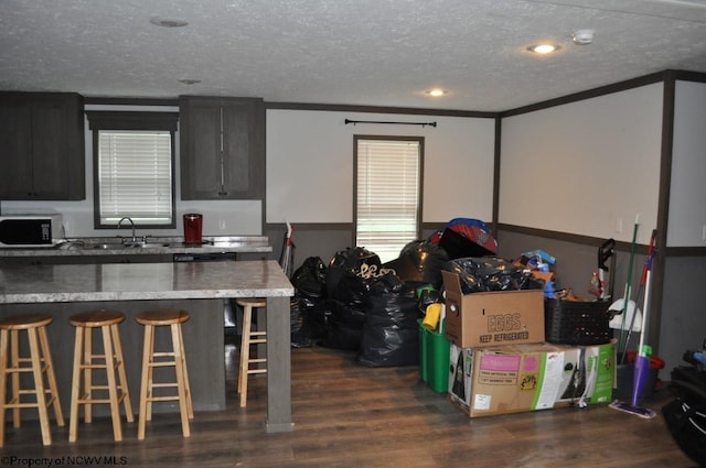 227 Joe Kincaid Rd, Fairmont, WV 26554 - kitchen with stainless steel microwave, a breakfast bar area, a textured ceiling, a sink, and dark wood-type flooring