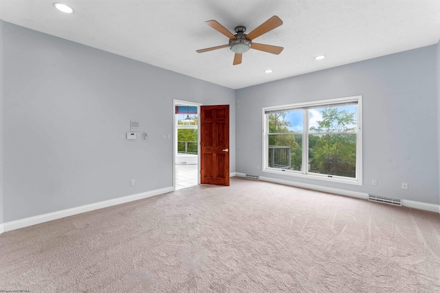 carpeted spare room featuring ceiling fan and plenty of natural light