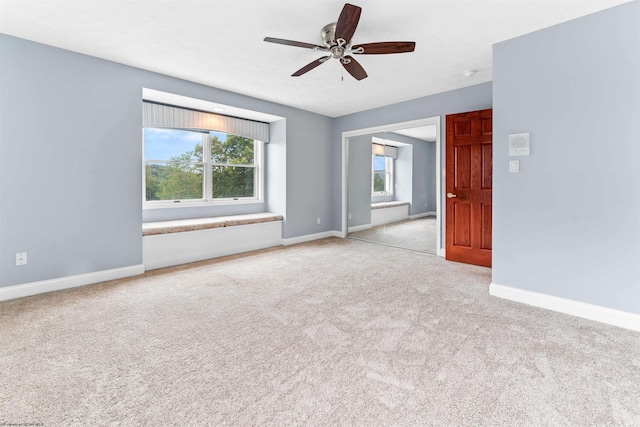 spare room featuring ceiling fan and light carpet