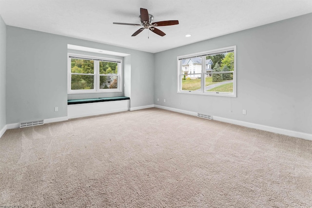 carpeted spare room featuring ceiling fan