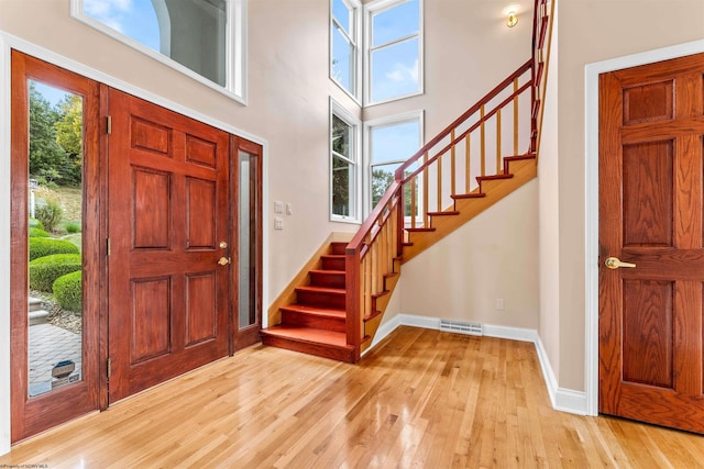 entrance foyer with a high ceiling and light hardwood / wood-style flooring