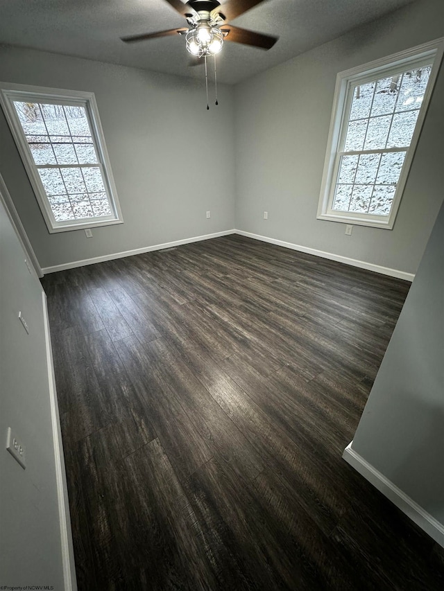 spare room with ceiling fan, dark hardwood / wood-style flooring, and a textured ceiling