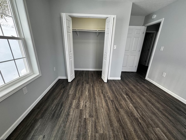 unfurnished bedroom featuring dark wood-type flooring and a closet