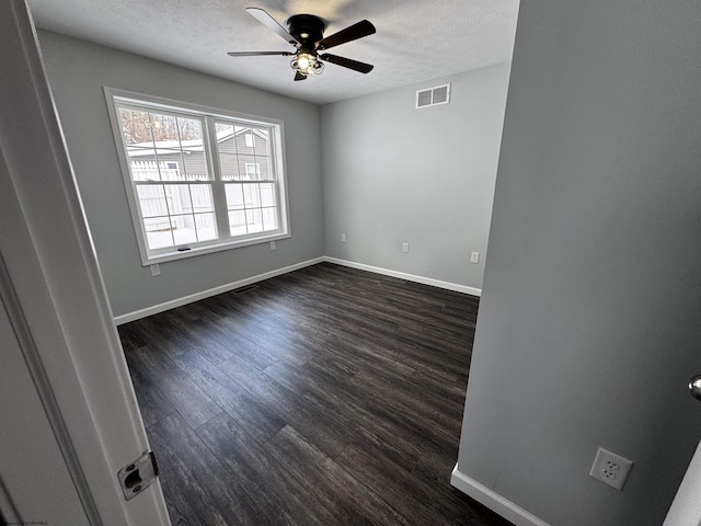 unfurnished room featuring ceiling fan, dark hardwood / wood-style floors, and a textured ceiling