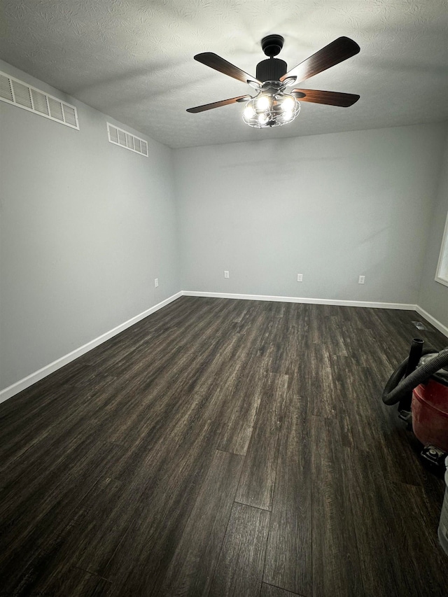 spare room featuring a textured ceiling, dark wood-type flooring, and ceiling fan