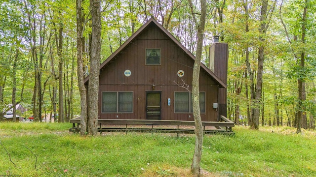 view of front of home with a deck and a front lawn