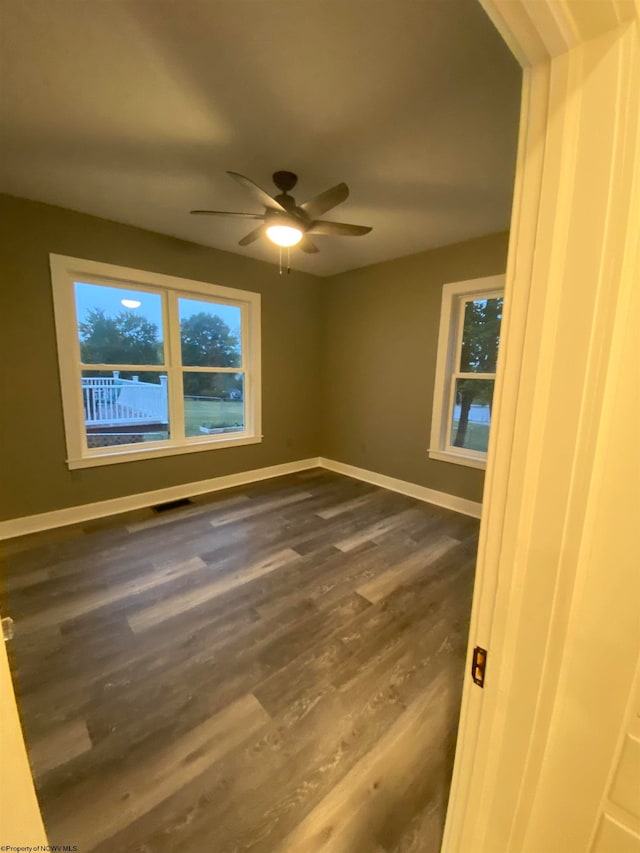 unfurnished room featuring dark hardwood / wood-style flooring and ceiling fan