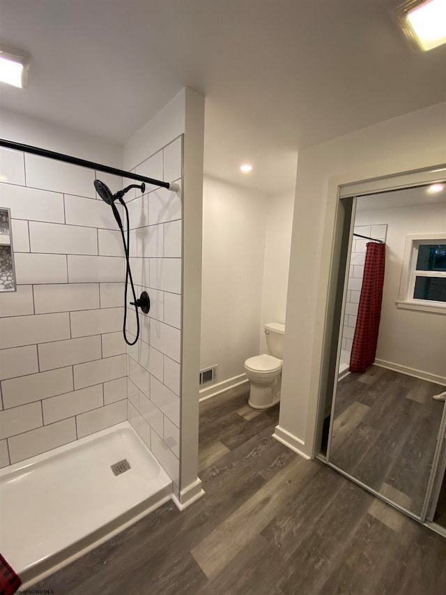 bathroom featuring curtained shower, toilet, and hardwood / wood-style flooring