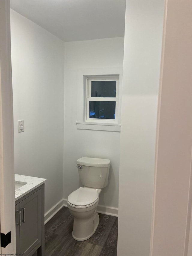 bathroom with hardwood / wood-style flooring, vanity, and toilet