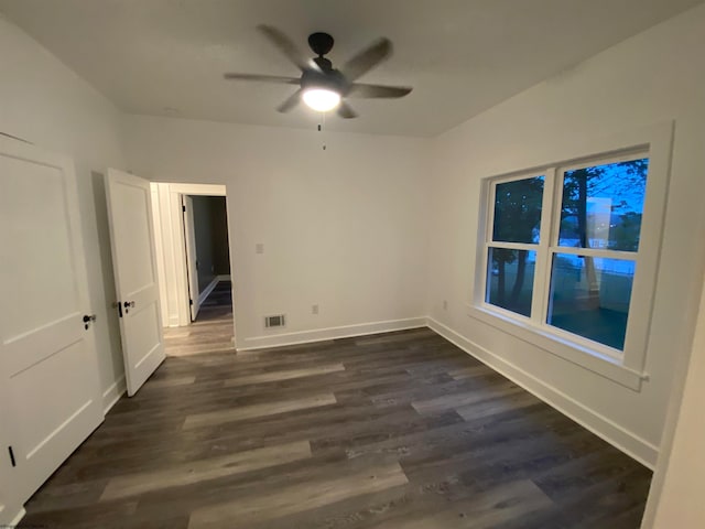 spare room with dark wood-type flooring and ceiling fan