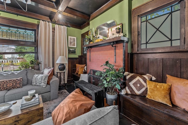 living room featuring wood walls, beam ceiling, and coffered ceiling