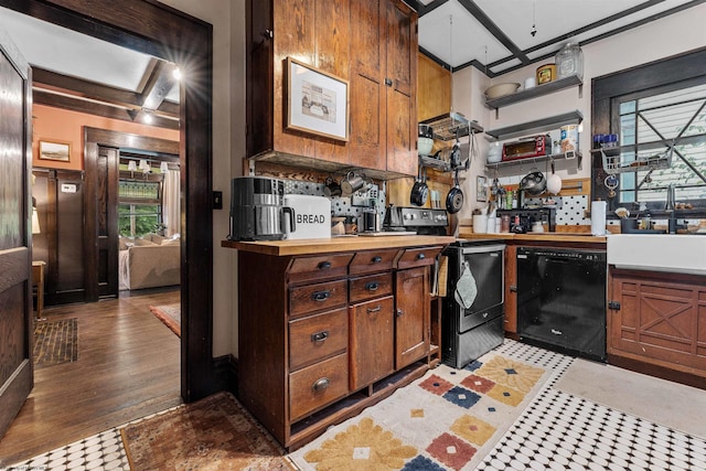 kitchen with black appliances, beamed ceiling, sink, and light hardwood / wood-style flooring