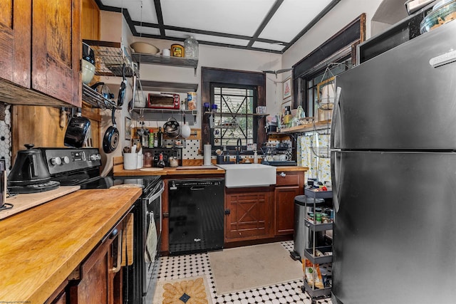 kitchen featuring stainless steel appliances, wooden counters, and sink