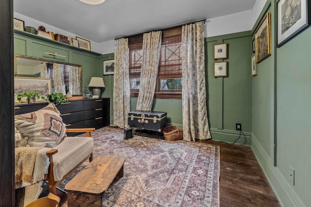 sitting room featuring a wood stove and dark hardwood / wood-style flooring