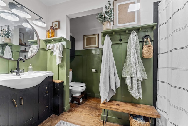 bathroom with vanity, toilet, and hardwood / wood-style flooring