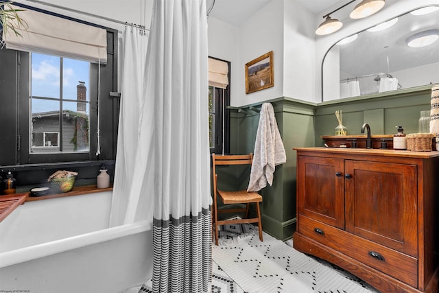 bathroom with shower / bath combo with shower curtain, tile patterned flooring, and sink