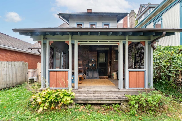 back of property featuring a deck and a sunroom