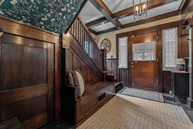 foyer featuring coffered ceiling, beamed ceiling, and wood walls