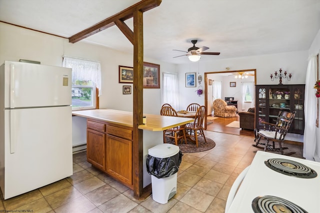 kitchen featuring a baseboard radiator, white refrigerator, light tile patterned flooring, and ceiling fan