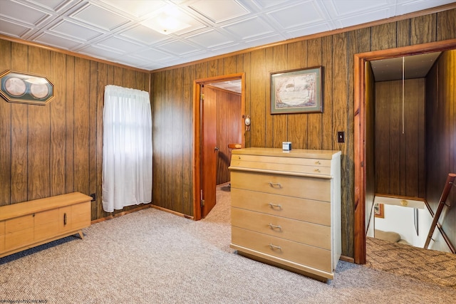 bedroom with wood walls and light colored carpet