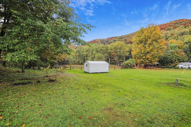 view of yard featuring a storage shed, a mountain view, and a rural view