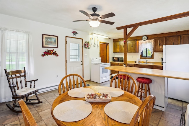 tiled dining space with ceiling fan, sink, and a healthy amount of sunlight