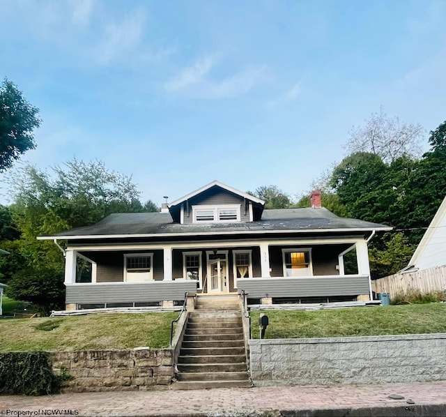 view of front facade with a front yard and covered porch