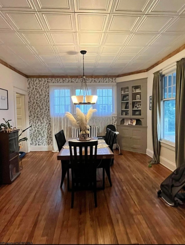 dining area with an inviting chandelier, plenty of natural light, dark wood-type flooring, and built in features