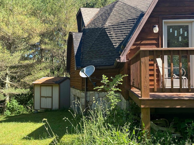 view of side of property with a shed, a deck, and a lawn