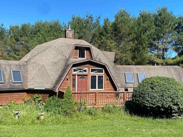 view of front of home featuring a wooden deck and a front yard