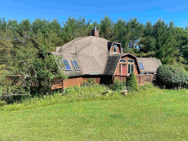 view of front of property with a wooden deck and a front yard