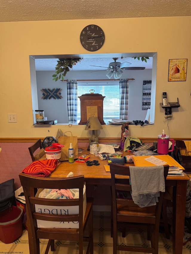 dining space with ceiling fan and a textured ceiling