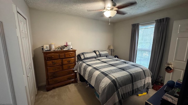 carpeted bedroom with a textured ceiling and ceiling fan