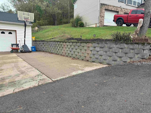 exterior space featuring a garage, concrete driveway, and a lawn